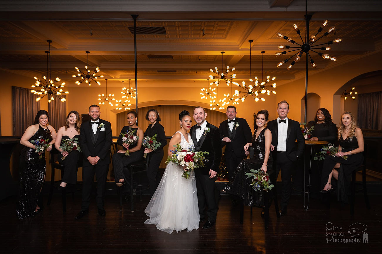 a wedding couple with their wedding party in a beautiful event venue with modern lighting and regal views